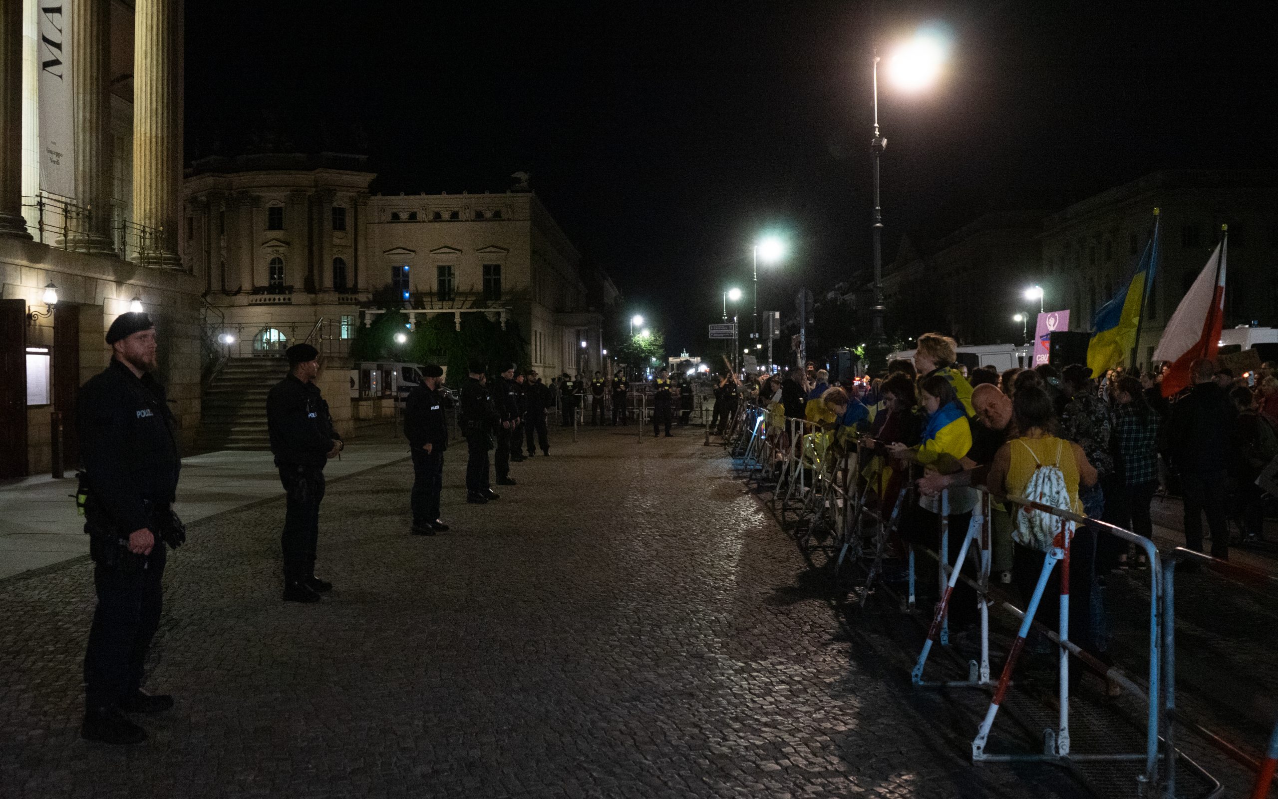 Polizisten schirmen die Opernbesucher von den Demonstranten ab
